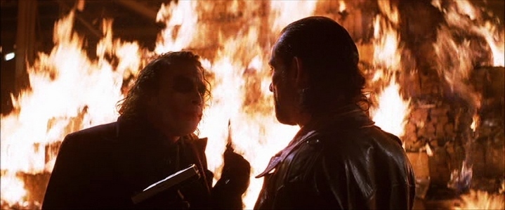 Le Joker (Heath Ledger) brûle la moitié de sa part d'argent... "Certaines personnes veulent juste voir le monde brûler" dit Alfred à Bruce Wayne dans The Dark Knight.